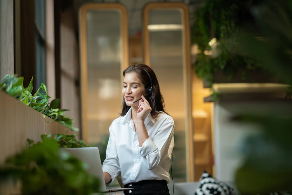 En kvinna står med ett headset i ett samtal