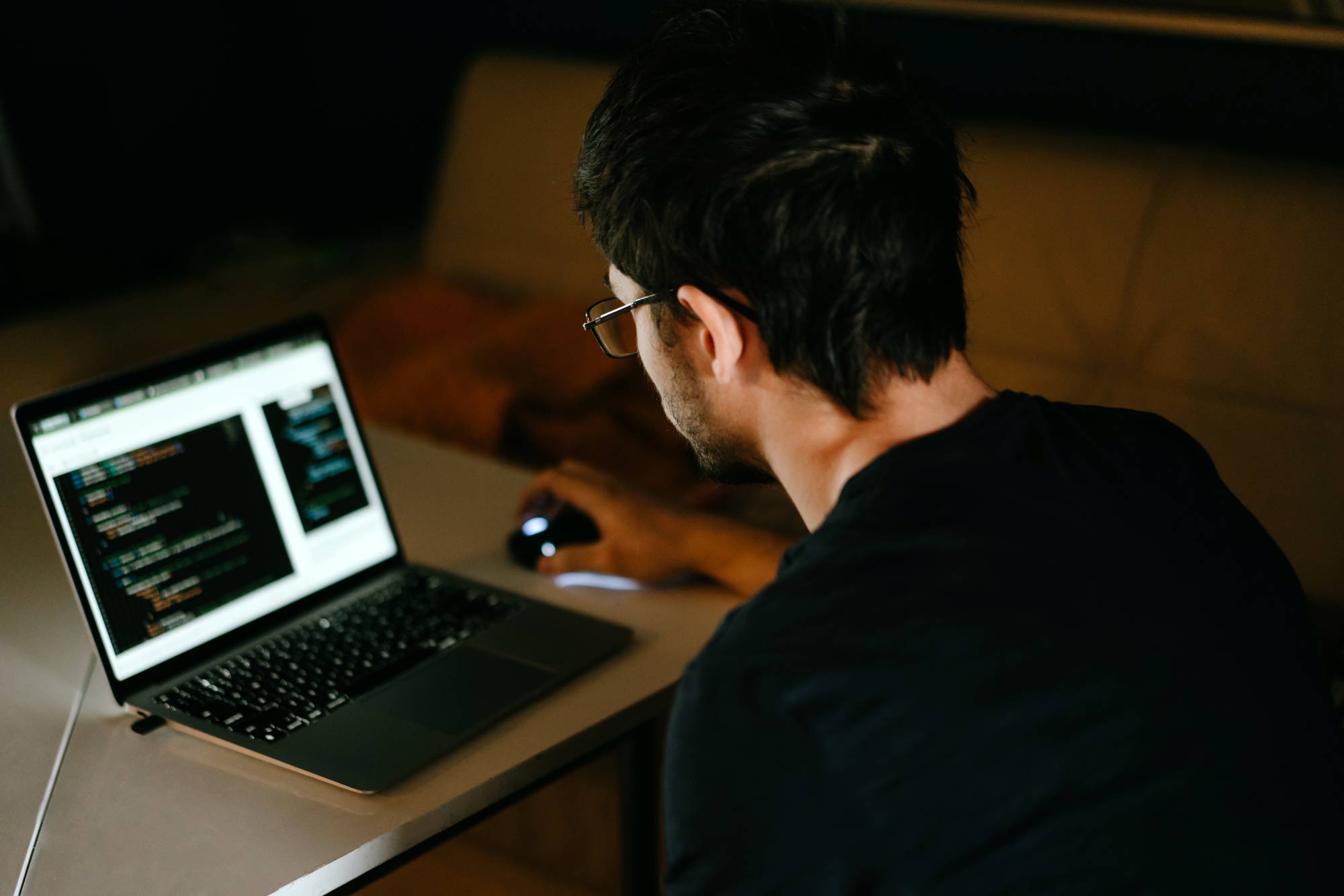 En person sitter med kod uppe i en laptop