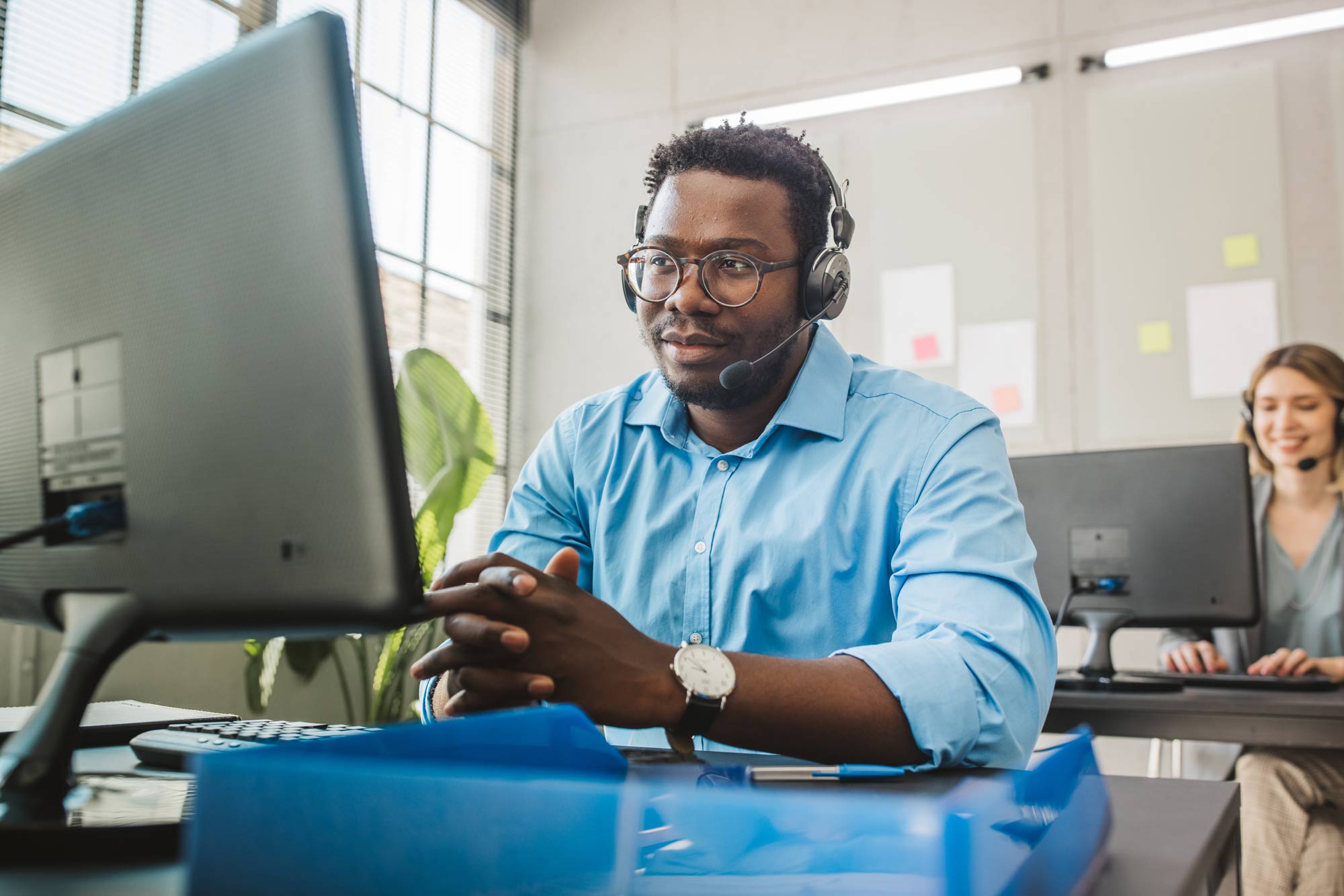 En man i headsett sitter och ger support.